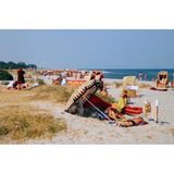 Die einen stricken, die anderen lesen oder genießen einfach die Sonne: Bei sommerlichen Temperaturen zieht es Badegäste an den weiten Strand der beliebten Ferieninsel Fehmarn.