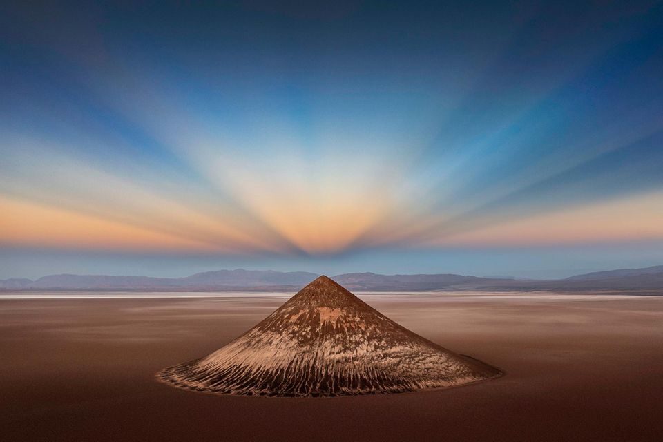 Surreal: Die Natur formte diesen geometrisch perfekten Bergkegel, der auf 3500 Metern über den Salzfeldern der argentinischen Anden thront. Noch magischer wirkt Cono de Arita im Licht der symmetrisch gespiegelten Gegendämmerungsstrahlen. Sie entstehen, wenn die Sonne kurz vor dem Aufgehen oder direkt nach ihrem Untergang hinter dem Horizont steht. "Es ist ein ganz besonderer Ort mit unglaublichen Möglichkeiten und sehr unterschiedlichen Blickwinkeln", sagt Fotograf Ignacio Palacios. Seine Drohnenaufnahme des Cono de Arita ist das "Foto des Jahres". 1.7297