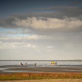 Wolkiger Himmel und Watt mit Wattwagenfahrt zur Insel Neuwerk