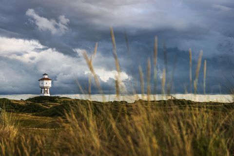 Wolkiger Himmel und Wasserturm auf der Insel Langeoog