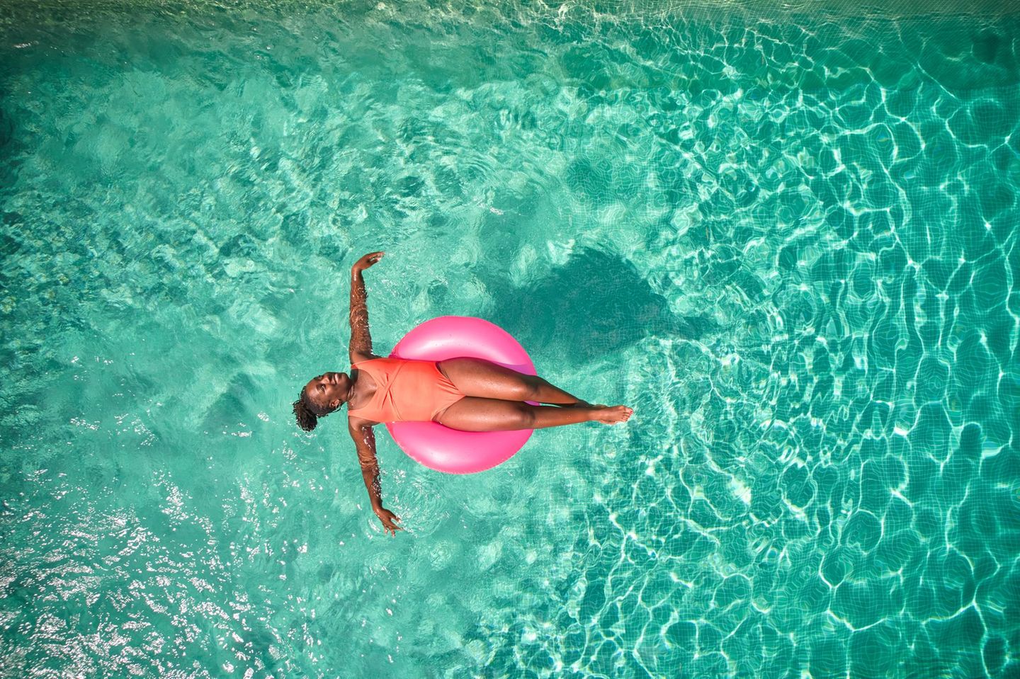 Eine Frau liegt in Schwimmring im Pool