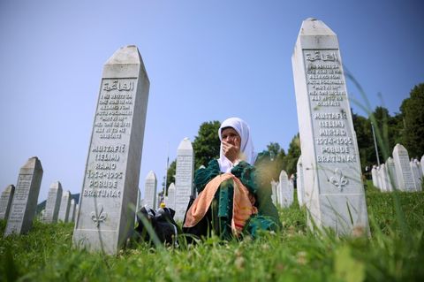Eine muslimische Frau trauert zwischen Grabsteinen um die Opfer des Massakers von Srebenica