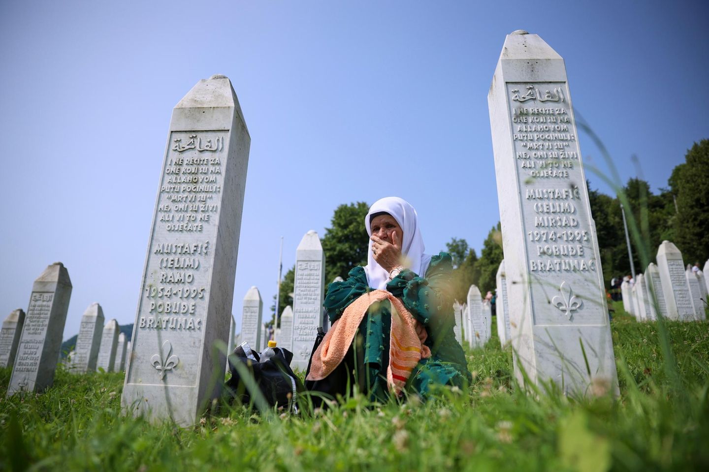Eine muslimische Frau trauert zwischen Grabsteinen um die Opfer des Massakers von Srebenica