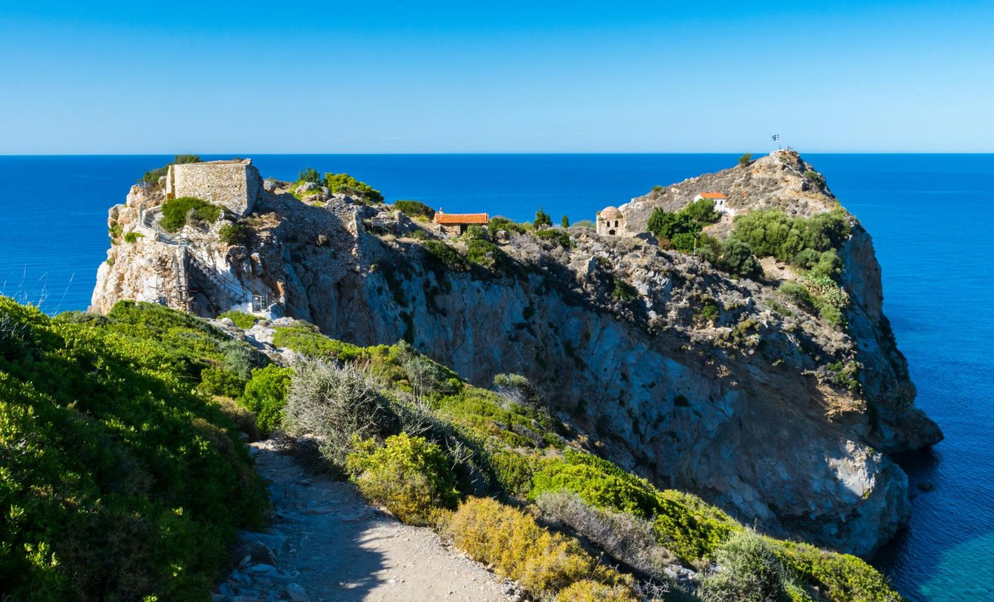 Blick auf Felsen, Meer und Ruinen der Stadt Kastro auf Skiathos