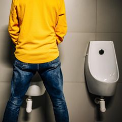 Paruresis: Mann steht an einem Urinal