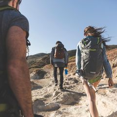 Drei Wanderer mit Reiserucksäcken