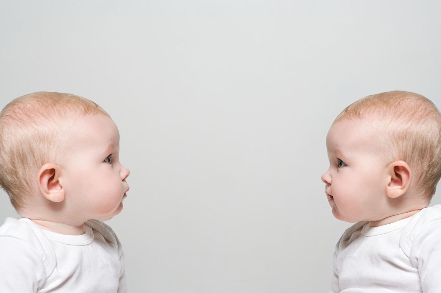 Zwei Babies sitzen sich gegenüber