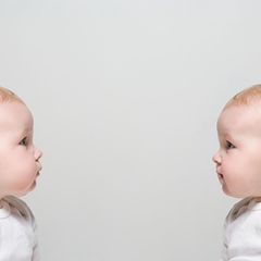 Zwei Babies sitzen sich gegenüber