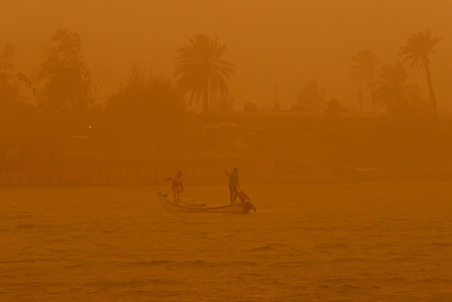 Fischer auf dem Schatt al-Arab während eines Sandsturms in Basra, eine Stadt im südlichen Irak