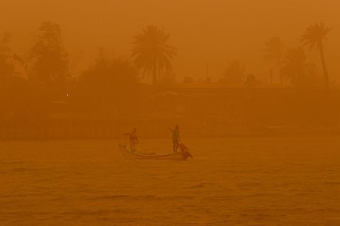 Fischer auf dem Schatt al-Arab während eines Sandsturms in Basra, eine Stadt im südlichen Irak