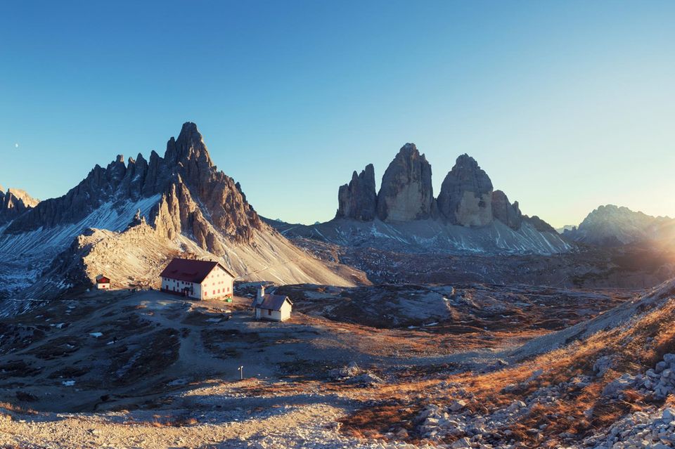 Berg-Panorama: Blick auf Schutzhütte Refugio Antonio Locatelli unweit der aufragenden Drei Zinnen bei Sonnenuntergang 1.7981