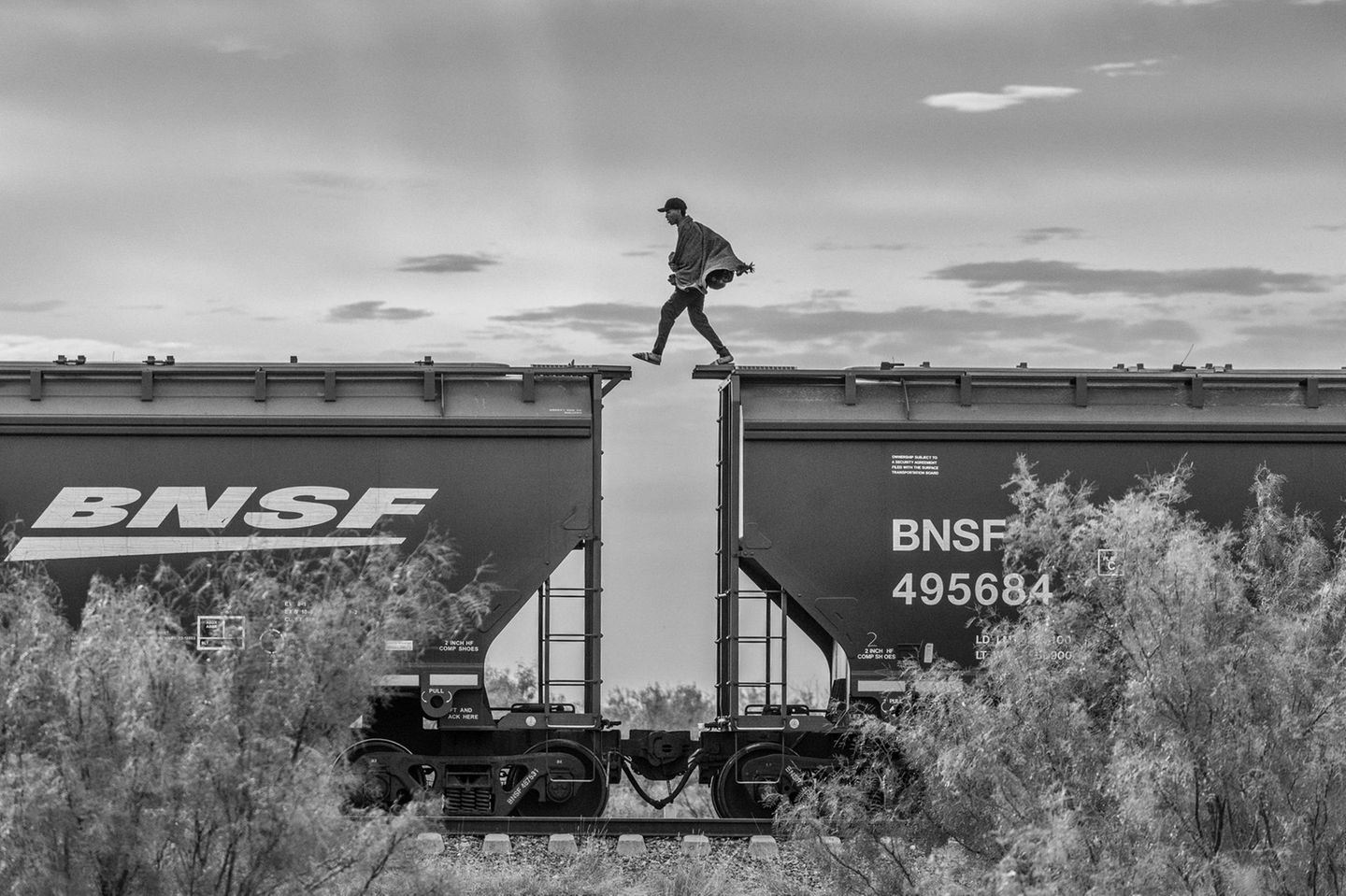Die Bestie Person läuft von Wagon zu Wagon auf den Dächern eines Zuges.