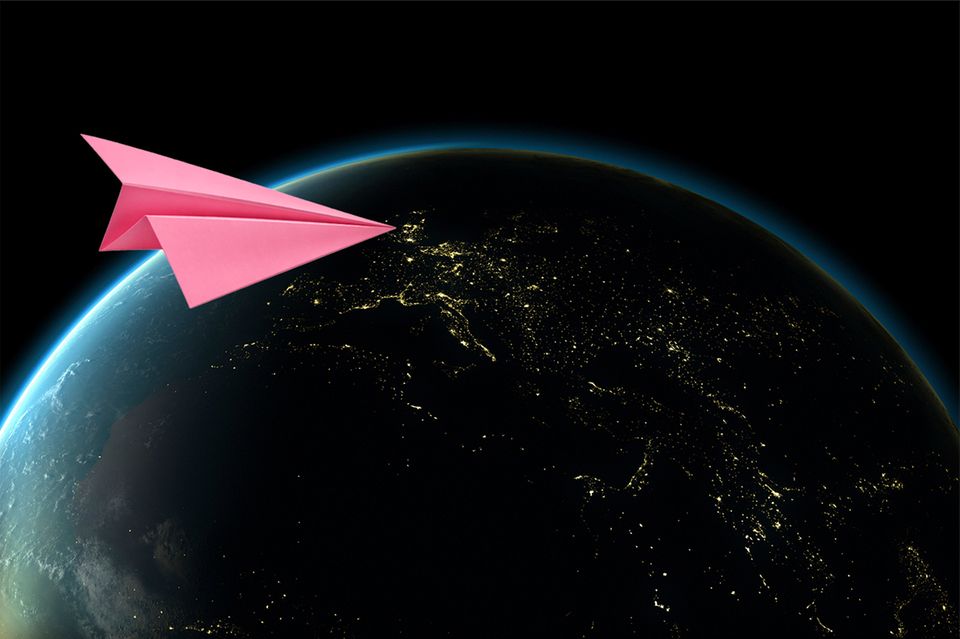 Ein pinker Papierflieger im Anflug auf die Erde (Illustration) 1.4989