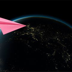 Ein pinker Papierflieger im Anflug auf die Erde (Illustration)