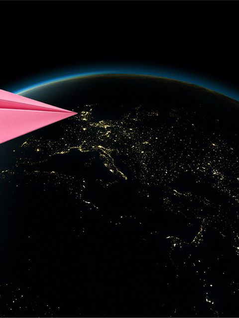 Ein pinker Papierflieger im Anflug auf die Erde (Illustration)