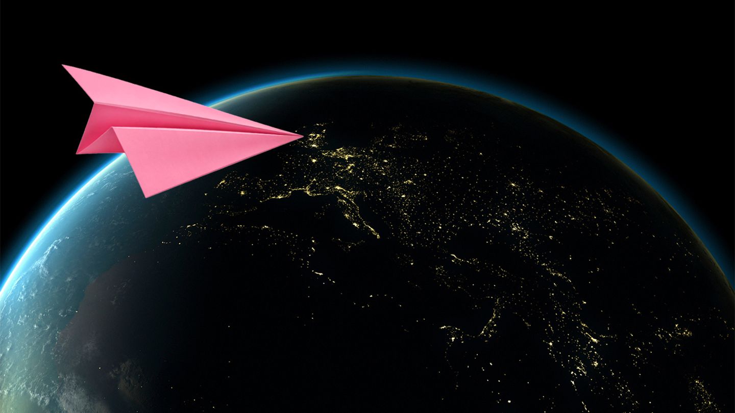 Ein pinker Papierflieger im Anflug auf die Erde (Illustration)