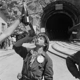 Ein Bergarbeiter trink aus ein Sektflache