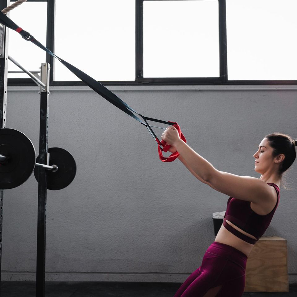 Frau setzt zyklusbasiertes Training beim Kraftsport um