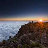 Eine Person im Sonnenaufgang über dem Nebelmeer am Pico de Ariero auf Madeira
