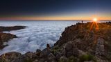 Eine Person im Sonnenaufgang über dem Nebelmeer am Pico de Ariero auf Madeira