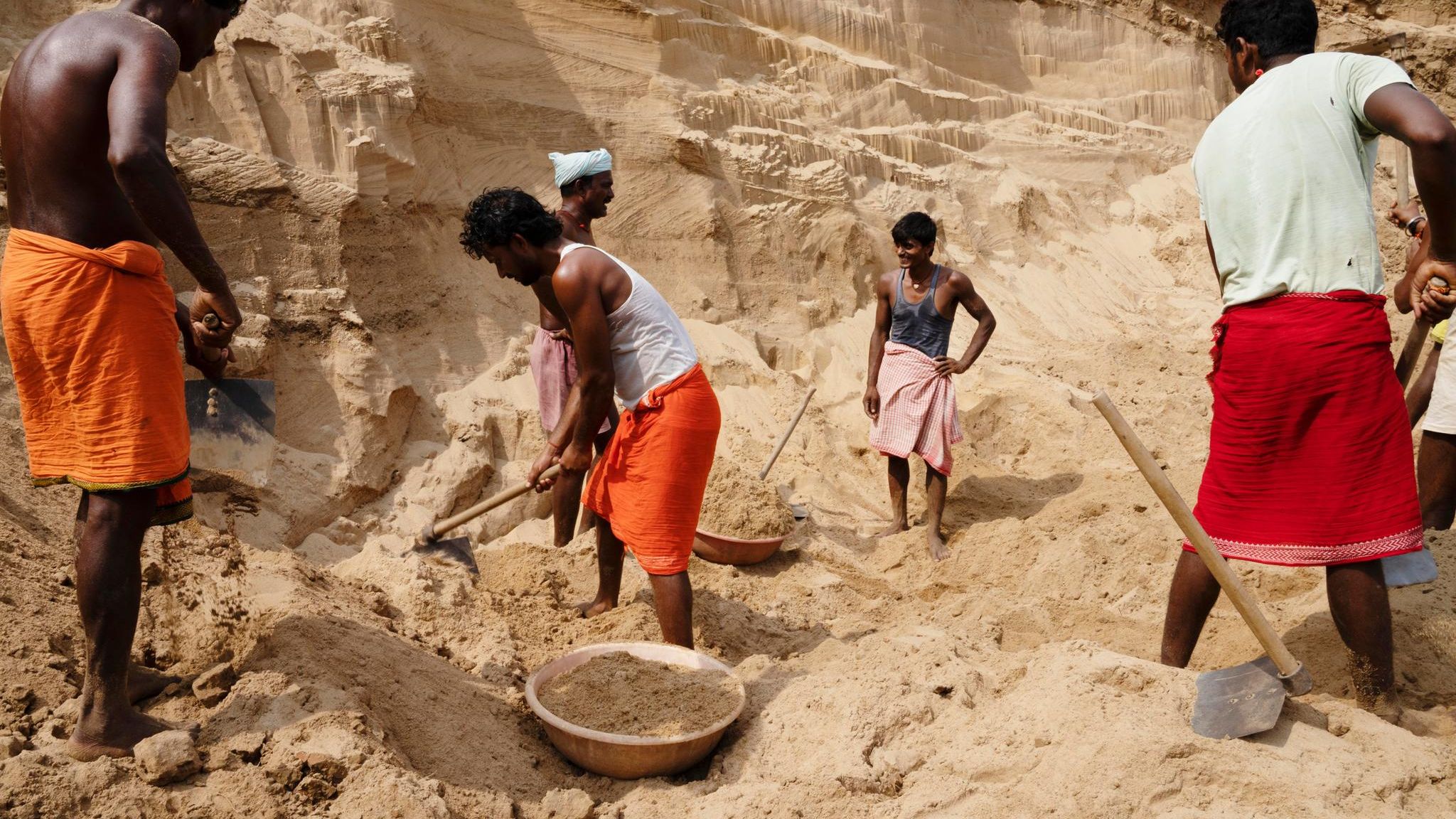 Schon seit dem Morgengrauen schaufeln Arbeiter Sand am Ufer des indischen Flusses Son. Die sandige Klippe über ihren Köpfen könnte jederzeit einbrechen und sie unter sich begraben. Sie werden überwacht von Männern, die das Gebiet kontrollieren