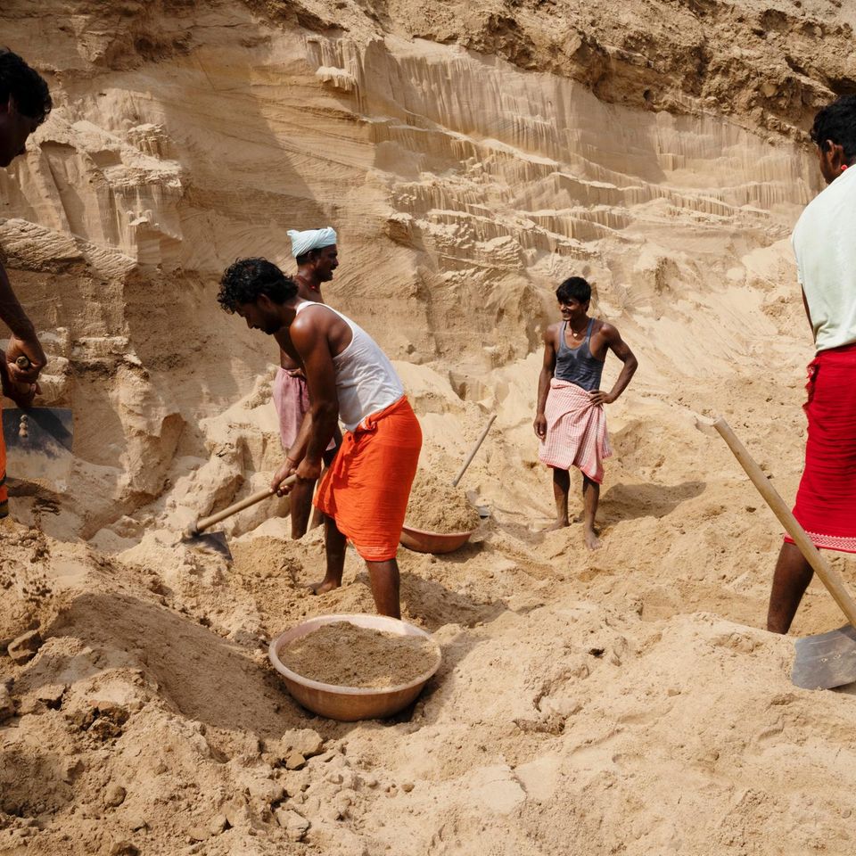 Schon seit dem Morgengrauen schaufeln Arbeiter Sand am Ufer des indischen Flusses Son. Die sandige Klippe über ihren Köpfen könnte jederzeit einbrechen und sie unter sich begraben. Sie werden überwacht von Männern, die das Gebiet kontrollieren