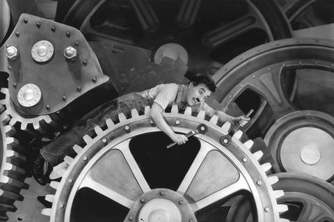 Szene aus Charlie Chaplins Film "Modern Times" von 1936, in der er auf einem Zahnrad liegt