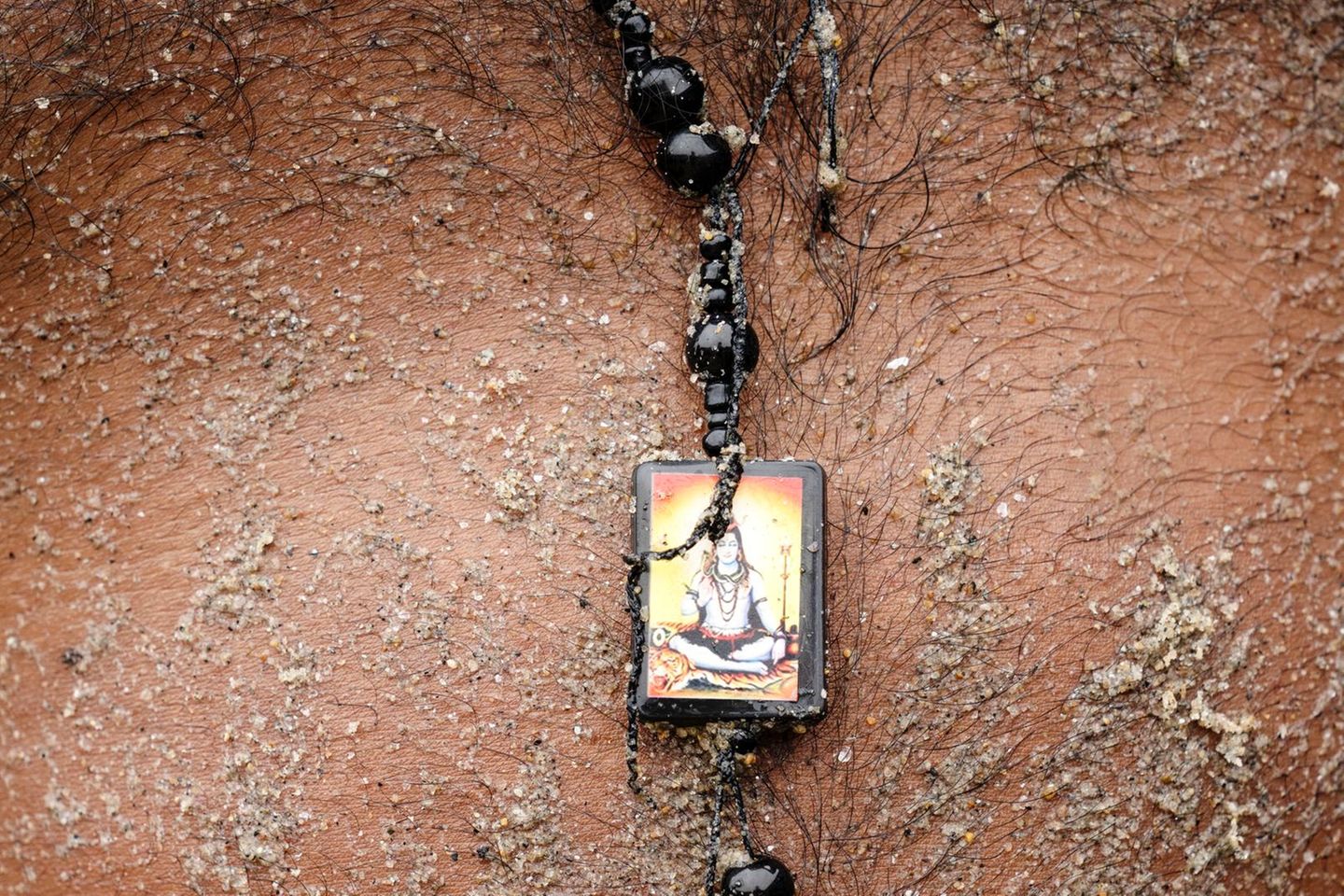 Sand verklebt die Haut und verfängt sich im Brusthaar eines Sandhändlers in Indien. Die Nachfrage nach Sand hat sich hier seit den frühen 2000er-Jahren schätzungsweise mehr als verdreifacht. Der Abbau ist zu großen Teilen illegal