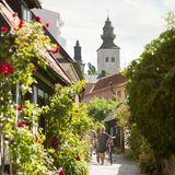 Spaziergänger schieben ihr Fahrrad durch die beblühmten Gassen der Altstadt von Visby