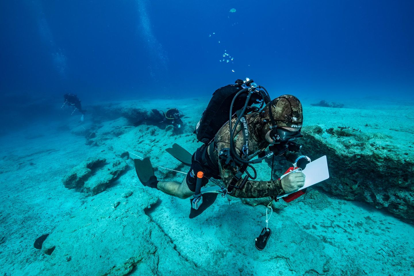 Riff-Patrouille Ein Wissenschaftler schreibt etwas Unterwasser auf eine Notiztafel