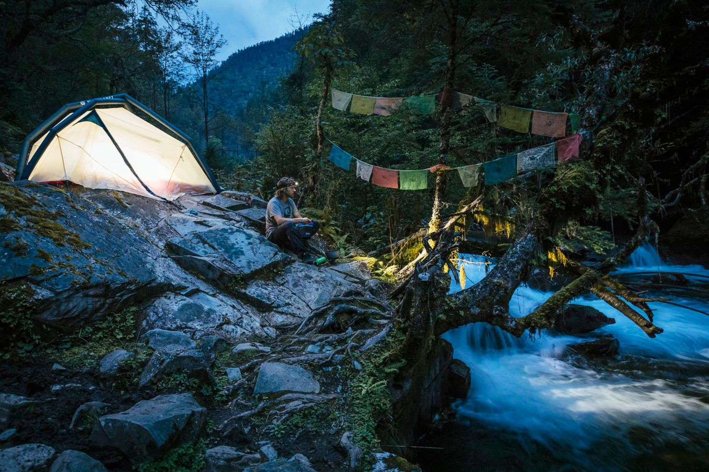 Khawa Karpo, Tibet Ein Mann sitzt vor seinem Zelt in den Bergen an einem Fluss