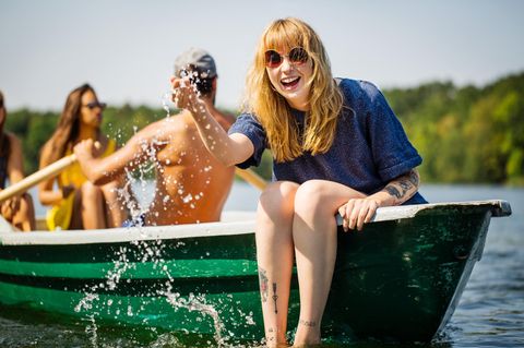 Frau sitzt lachend in einem Boot