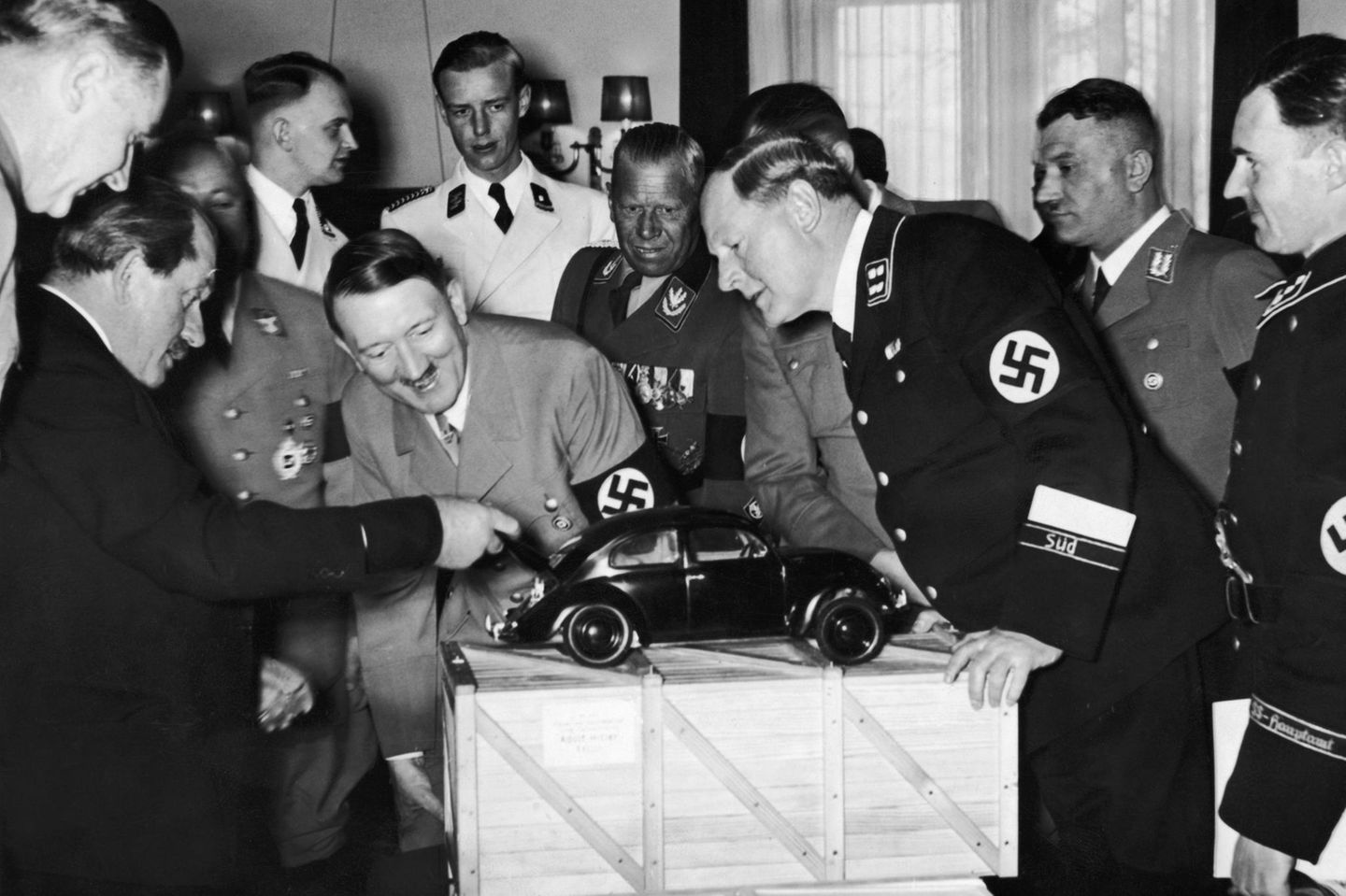 Auftrag für ein "Volksauto" Porsche und Hitler schauen auf ein VW-Käfer Modell