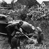 Eine Familie picknickt vor einem Volkswagen, 1940er-Jahre