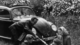 Eine Familie picknickt vor einem Volkswagen, 1940er-Jahre