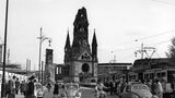 Ein Käfer fährt in der Nachkriegszeit über den Berliner Ku’damm