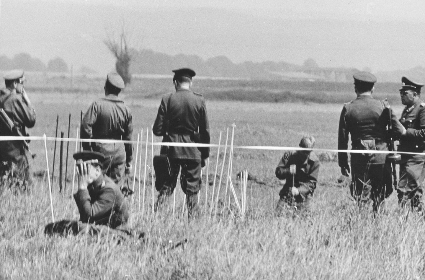 Gut bewacht Grenzpolizisten bewachen einen Arbeiter, der die Grenzanlagen in Hünfeld ausbaut, 1962