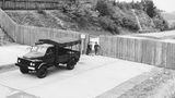 Menschen schauen durch eine Tür in einem Bretterzaun an der Saale-Autobahnbrücke bei Hof, 1962