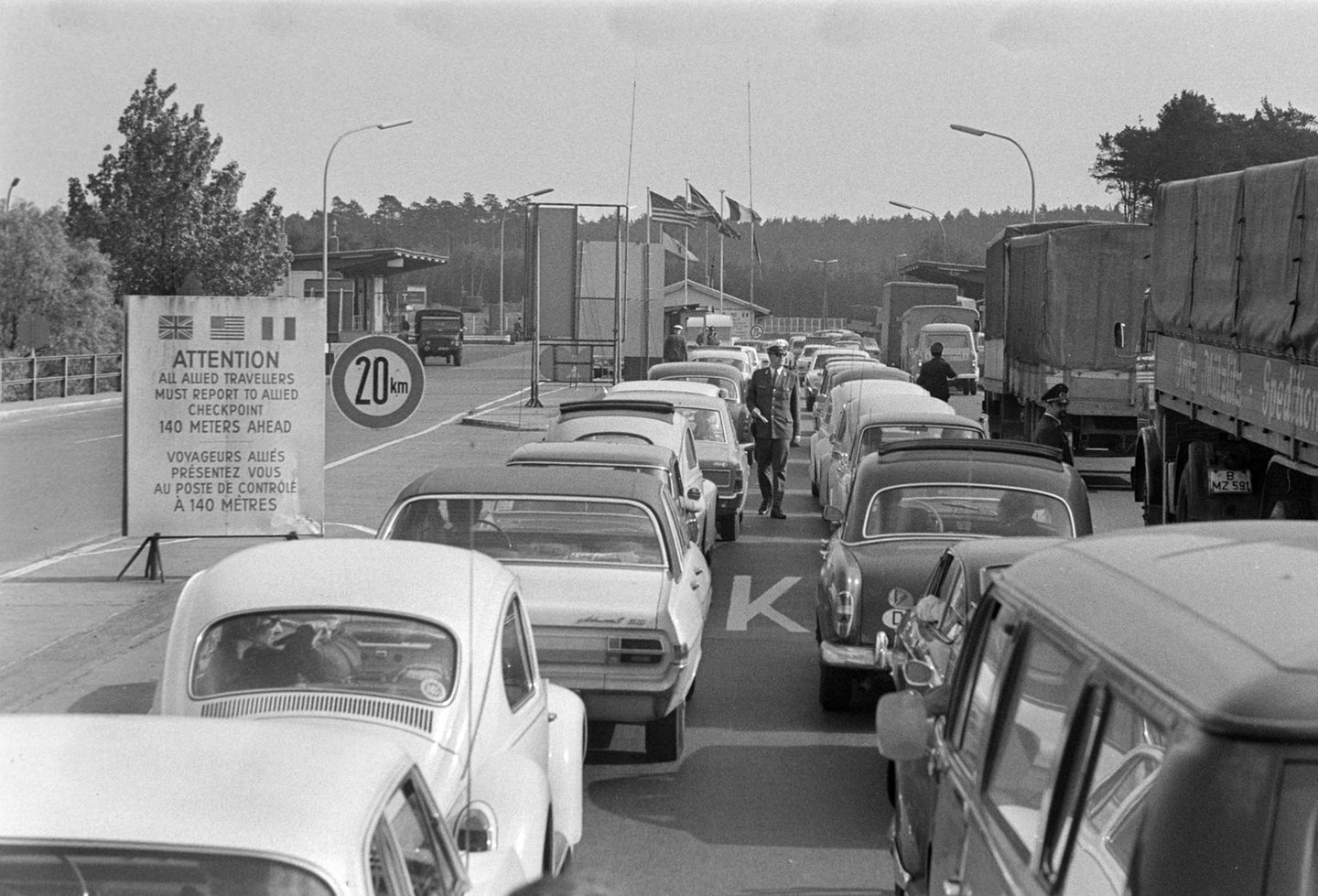 In der Zeit der deutschen Teilung bezeichnet der Transitverkehr die speziell geregelte Durchreise von Personen und auch Gütern durch das Gebiet der DDR. Einige wenige Transitstrecken verbinden damals den westlichen Teil Berlins mit der Bundesrepublik. An den innerdeutschen Grenzen werden die Pässe kontrolliert und der Reiseverkehr streng überwacht. Deshalb kommt es an den Kontrollpunkten, wie hier in Babelsberg 1969, häufig zu längeren Staus. Erst ab 1972 erleichtert ein Transitabkommen den Verkehr zwischen der BRD und West-Berlin deutlich.