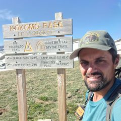 Links ein Berg und Rechts Robert Stiepani auf einem Pass