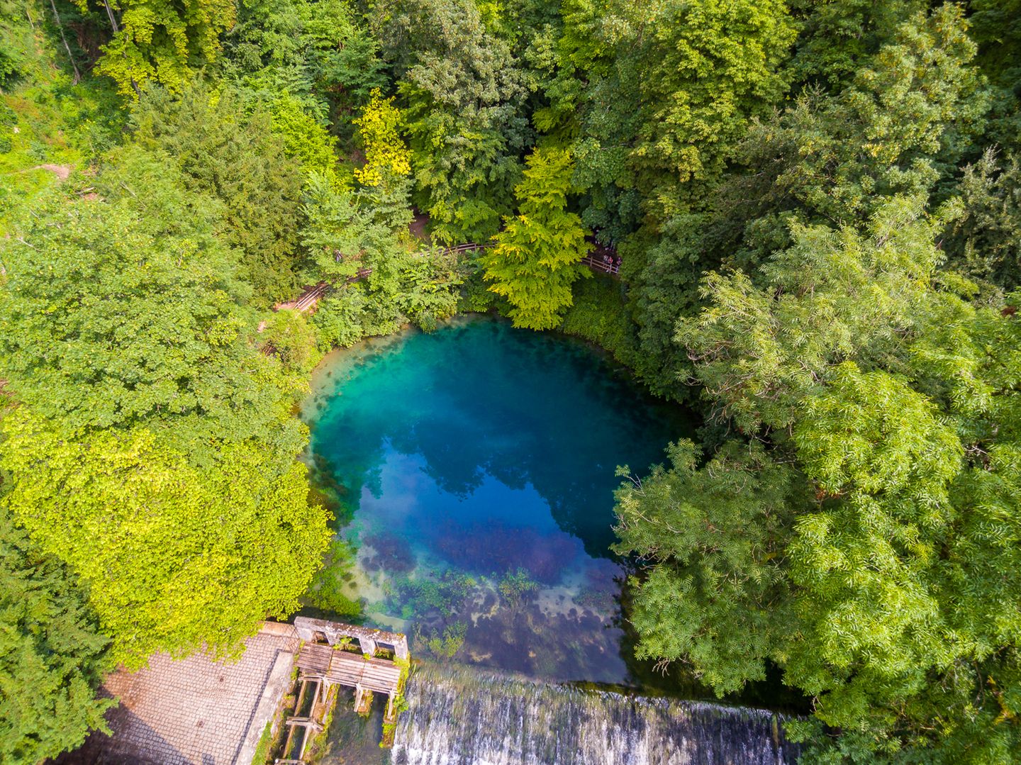Wer nicht schon einmal am Blautopf gestanden hat, wird kaum glauben, wie tief blaugrün Wasser leuchten kann. Der glasklare Tümpel ist eine Karstquelle, aus der der gleichnamige Bach, die Blau, entspringt. Und der zugleich der Eingang zu einem der am weitesten verzweigten und längsten Höhlensysteme Deutschlands ist. Das Naturjuwel gehört zum Geopark Schwäbische Alb und liegt direkt am Blaubeurer Felsenstieg.