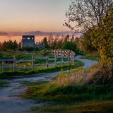 Ein Pfad führt über eine Wiese, links ist er durch einen Holzzaun begrenzt