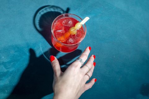 Frauenhand greift nach einem Cocktailglas