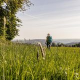 Frau in Wiese unterwegs auf dem Kammweg Erzgebirge-Vogtland