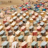 Bruch mit der Symmetrie, wechelhaften, und doch gleichförmig "angeordnete" Erholung wird karikiert mit dem Potpurri an bunten Liegestühlen und Windfängern  