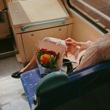 Geschichte passiert sofort im Kopf, wer bekommt die Blumen? Freudige Erwartung der abgebildeten Person sichtbar, ohne dass man das Gesicht sehen muss, Moment des Augenblicks, im Vorübergehen gesehen, kleinen Momente im Alltag, die schnell untergehen festgehalten