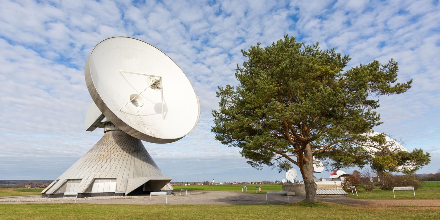 Radom Raisting, Bayern Raisting, Germany - Nov 13, 2020: Panorama with a huge satellite dish. Standing next to a tree.