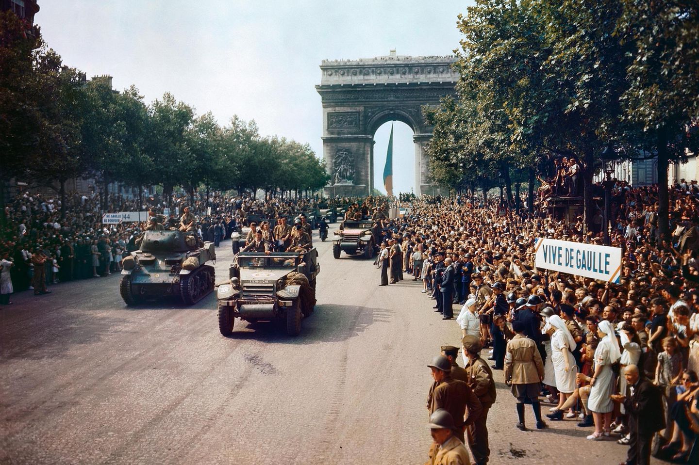 Nach der Befreiung von Paris saeumen Menschen die Champs Elysees beim Durchzug der all
