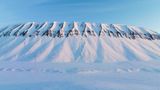 Während der Rest der Welt dem Frühling entgegenblickt, beginnt im hohen Norden der sonnige Winter. Der Februar schimmert noch in sanften Pastelltönen, doch das Licht kehrt zurück. Mitte März erlebt Spitzbergen bereits acht Stunden Sonne täglich – und mit ihr erwacht die Insel. Schneemobile gleiten durch gefrorene Täler, erreichen Gebiete, die monatelang nicht zugänglich waren. Die Bewohner fahren hinaus, campen in einsamen Hütten und beobachten Polarfüchse, Rentiere und Robben in der weiten, stillen Landschaft. Jetzt zeigt sich die Arktis von ihrer schönsten Seite – hell, klar und scheinbar grenzenlos. Die Sonne scheint nun Tag für Tag etwas länger, bis sie am 19. April gar nicht mehr untergeht.