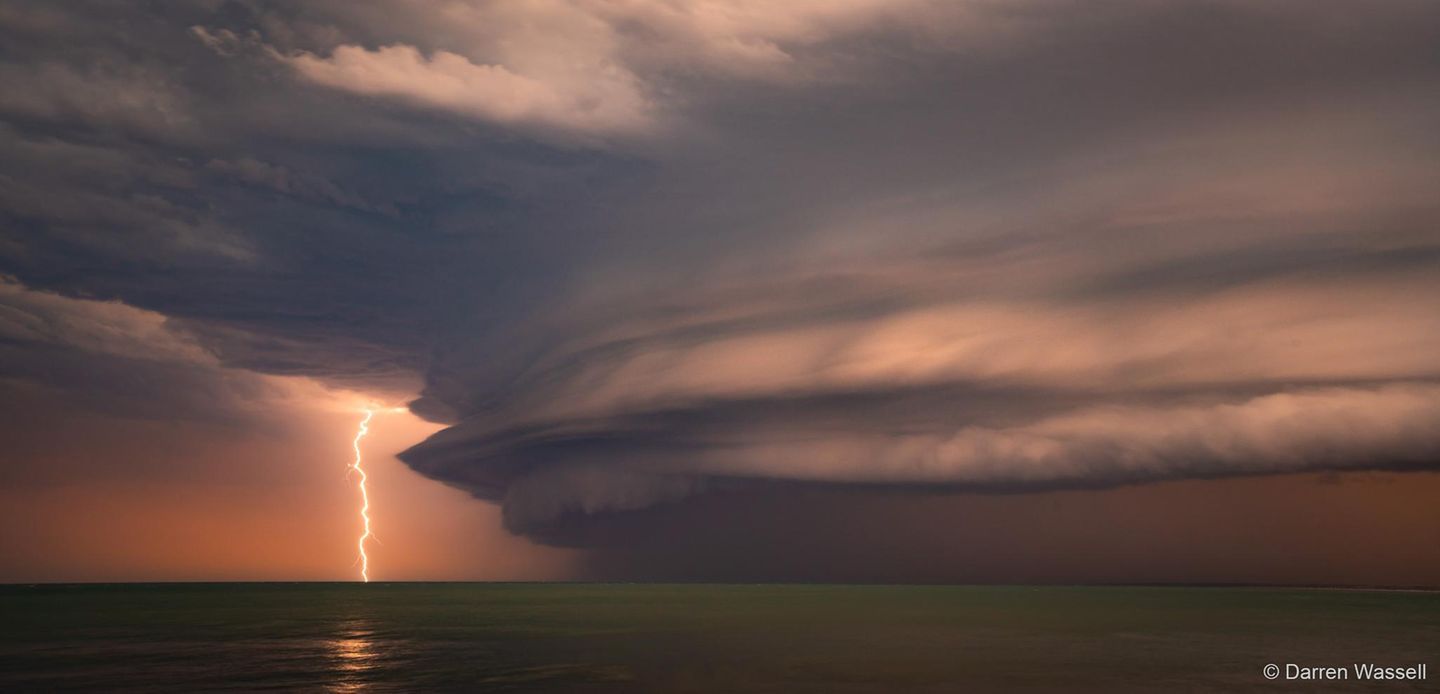Sieg in der Kategorie Landschaft: "Das Biest" Wuchtiges Unwetter: Eine gewaltige Wolkenformation schiebt sich über die Küste, eingefangen am australischen Kings Beach. Fasziniert von dieser Urgewalt wartete Fotograf Darren Wassell auf den entscheidenden Moment – und erwischte den einzigen Blitz, der sich aus der Wolke zur Erde entlud. Ein Bild von elementarer Kraft, das die australische Natur in ihrer atemberaubenden, unbändigen Form einfängt.